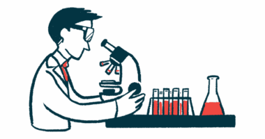 A researcher studies samples under a microscope alongside a rack of vials and a beaker.