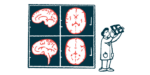 A doctor holds up a slide next to enlarged images of a brain.