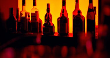 Bottles of liquor behind a bar in low lighting