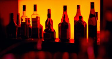 Bottles of liquor behind a bar in low lighting