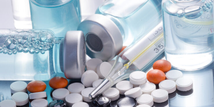 PIlls and vials of fluid surrounding an injectable