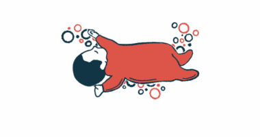 A baby in a onesie is shown sleeping.