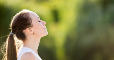 A woman with her eyes closed practicing deep breathing