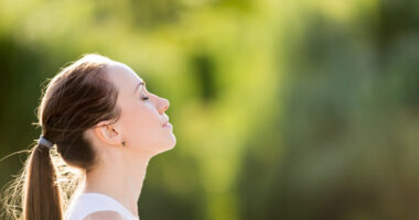 A woman with her eyes closed practicing deep breathing